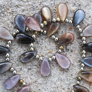 May include: A white ceramic mug with a black handle and the text "But First, Coffee" in a handwritten style. The mug is on a white surface. The mug is approximately 4 inches tall.