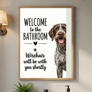 Op de afbeelding: Een rechthoekige wandprint met een bruin-witte draadharige hond die vanaf de zijkant kijkt. De tekst luidt: WELCOME to the BATHROOM, a Wirehair will be with you shortly, met een klein zwart hartje gecentreerd tussen de tekstregels.