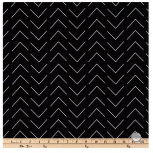 May include: Black fabric with a white chevron pattern. The fabric is measured with a ruler in inches.