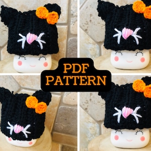 May include: A black crochet cat hat with orange bow and white embroidered eyes and whiskers. The hat is sitting on a white ceramic mug with a smiling face. The text "PDF PATTERN" is in the center of the image.