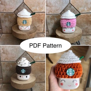 May include: Four crocheted coffee cup cozies in different colors and designs. The cozies are topped with whipped cream and a green leaf. The cozies are designed to fit a standard-sized coffee cup. PDF Pattern.