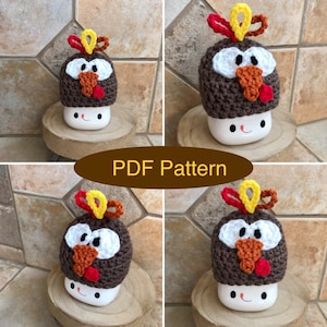May include: Four crocheted turkey hats in brown, white, and orange. The hats are sitting on white ceramic mugs with a brown rim and a painted face. The mugs are sitting on wooden coasters.