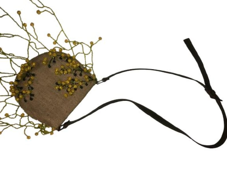May include: A small brown purse with a beaded fringe and a black adjustable strap. The beads are yellow and green.
