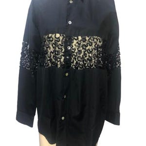 May include: A black long-sleeved button-down shirt with a lace panel across the chest.