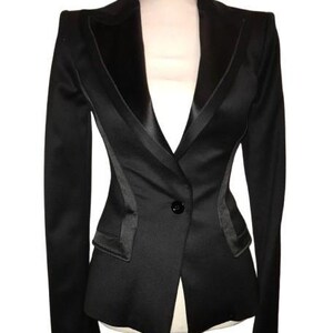 Può includere: Un blazer nero con revers in satin e chiusura con un solo bottone.