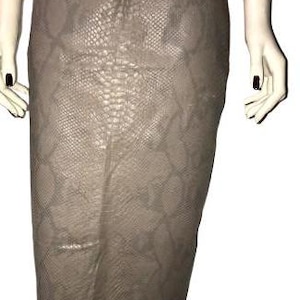 Puede incluir: Una falda de color marrón con estampado de piel de serpiente y silueta ajustada.