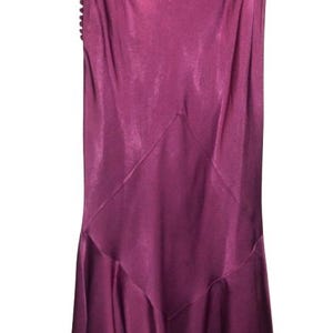 May include: A long, flowing purple satin skirt with a ruffled hem. The skirt has a simple, elegant design and is perfect for a special occasion.