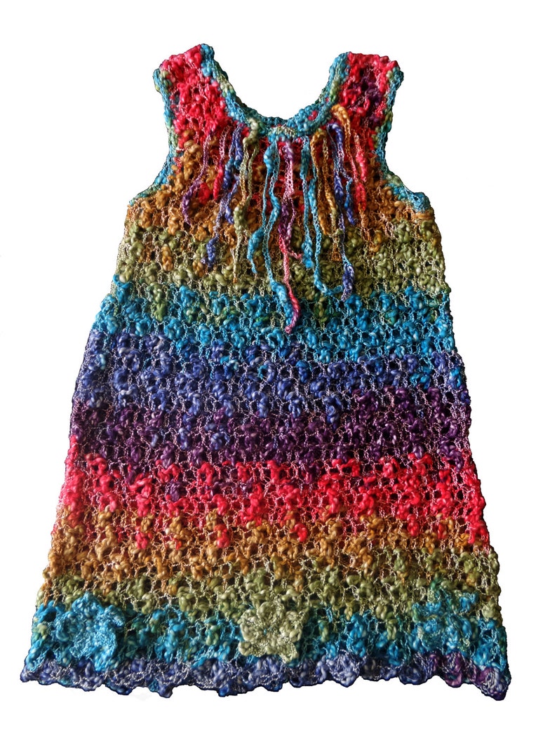 May include: A sleeveless, rainbow-colored crochet dress. The dress features a textured, open weave design with horizontal stripes of red, orange, yellow, green, blue, and purple. The neckline and hem have a scalloped edge, and the top has dangling fringe.
