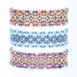 Może przedstawiać: Trzy bransoletki z koralików w różnych kolorach. Górna bransoletka jest brązowa, złota i zielona. Środkowa bransoletka jest niebieska i zielona. Dolna bransoletka jest różowa, złota i srebrna.