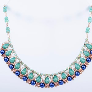 May include: A delicate necklace with a graduated design of teal and blue beads. The necklace features a central row of larger, teardrop-shaped beads, surrounded by smaller, round beads.