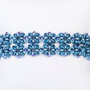 May include: A blue and teal beaded bracelet with a geometric pattern. The bracelet is made with small, round beads and is designed in a repeating pattern of squares.
