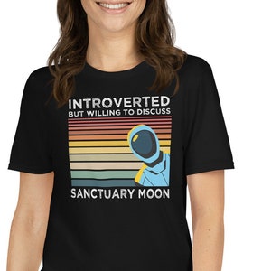 May include: Black t-shirt with a retro-style graphic featuring an astronaut and the text "Introverted but willing to discuss Sanctuary Moon".