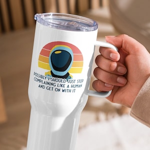 May include: White travel mug with a handle and a lid. The mug features a graphic of an astronaut helmet against a sunset design, with the text "Possibly I should just stop complaining like a human and get on with it."