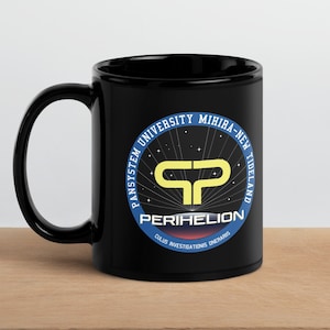 May include: Black ceramic coffee mug with a white and blue circular logo featuring the text "Pansystem University Mihira-New Tideland" and "Perihelion" with a yellow "P" symbol.