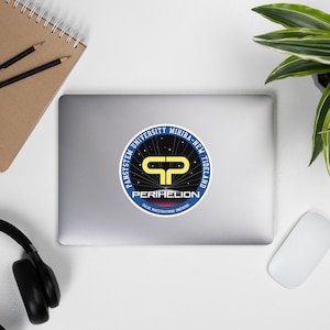 May include: A blue and yellow circular sticker with the text "PANSYSTEM UNIVERSITY MIHIBA-NEW TIDELAND" and "PERIHELION" with the text "CALUS INVESTIGATIONS, DREAMING" underneath.