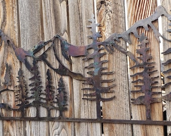 Metalowa dekoracja ścienna z motywem gór i drzew