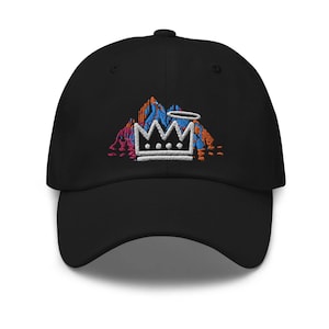 May include: Black baseball cap with an embroidered design of a crown on a mountain with a halo above it. The crown is white with three dots on the top and the mountain is blue, orange, and pink.