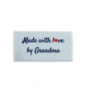May include: White satin label with blue text that reads "Made with love by Grandma" with a small red heart.