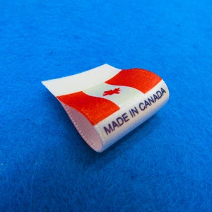 May include: White fabric label with a red and white Canadian flag and the text "MADE IN CANADA" printed in blue.