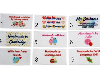 Op de afbeelding: Negen witte satijnen labels met verschillende ontwerpen en tekst. De labels zijn genummerd van 1 tot en met 9. De ontwerpen omvatten bloemen, harten, vogels, knoppen en een kerstmis-hulsttak. De tekst omvat "Handmade with love", "Handmade in Cambridge", "My Business", "Handmade by Julie", "With love from Sarah", "Handmade by Grandma Julie", en "Handmade by Sarah Christmas 2021".