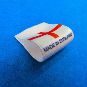 May include: White fabric label with a red cross and the text "MADE IN ENGLAND" in blue lettering.
