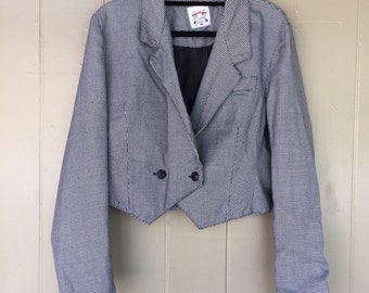 May include: A black and white houndstooth cropped blazer with a double-breasted closure and long sleeves.