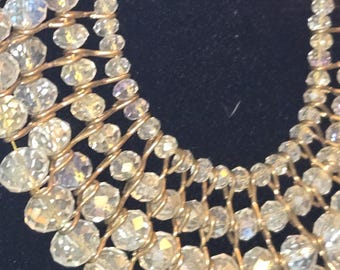 mehrsträngige Perlenkette mit facettierten Perlen, angeordnet auf goldfarbenen Ketten