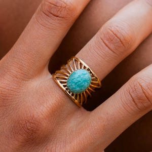 以下が含まれることがあります： 太陽の光線デザインにセットされたターコイズの宝石が付いた金の指輪