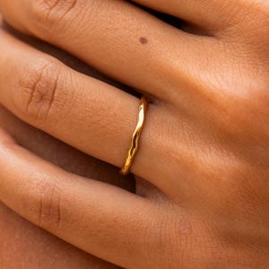 Op de afbeelding: Een dunne gouden ring met een gehamerde textuur.