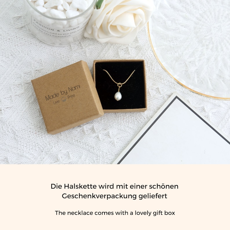 May include: A delicate gold chain necklace with a single white pearl pendant. The necklace comes in a brown gift box with the text "Made by Nami Live Free".