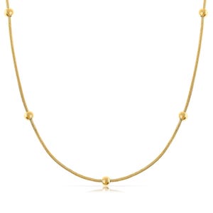 May include: A gold chain necklace with five round beads.