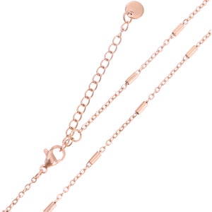 May include: A rose gold chain necklace with a lobster clasp and a small round disc at the end. The chain has a delicate design with small, round links.