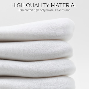 May include: Close-up of a stack of white fabric. The fabric is soft and smooth, and it is folded neatly. The text "HIGH QUALITY MATERIAL 83% cotton, 15% polyamide, 2% elastane" is visible at the top of the image.
