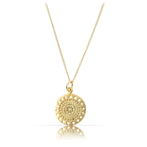 K&ouml;nnte beinhalten: Eine goldene Halskette mit einem runden Anh&auml;nger, der ein detailliertes Mandala-Design zeigt.
