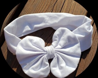 May include: A white fabric headband with a large white bow. The headband is made of a soft, stretchy material and is perfect for adding a touch of style to any outfit.