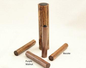 Könnte beinhalten: Vier Holzstift in verschiedenen Holzarten: Bocote, Purple Walnut und zwei weitere Bocote Stifte. Die Stifte sind alle etwa 25 cm lang und haben eine glatte, polierte Oberfläche.
