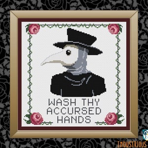 May include: A cross-stitch pattern featuring a plague doctor wearing a black hat and mask with the text "Wash Thy Accursed Hands". The pattern is framed in a gold frame with red roses on the corners.