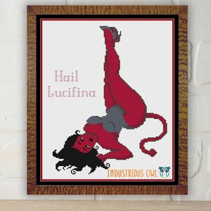 May include: Cross stitch pattern featuring a red-skinned woman with a tail, horns, and a halo. The woman is in a pin-up pose with the text "Hail Lucifina" above her. The pattern is by Industrious Owl.