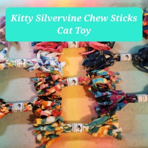 May include: Assortment of colorful cat toys made from knotted fleece fabric. The toys are labeled "Kitty Silvervine Chew Sticks Cat Toy".
