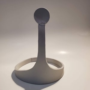 May include: A white ceramic crown with a rounded top and a circular base. The crown is a simple design with a smooth finish.