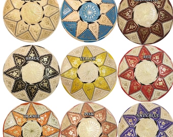 May include: A collection of round, patterned Moroccan poufs in various colors, including natural, blue, chocolate, red and black, black, yellow, red, orange, pink, and navy blue. Each pouf features a central design and geometric patterns.