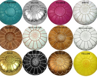 May include: A collection of round, leather poufs in various colors, including turquoise, silver, fuchsia, white, brown, gold, black and white, and yellow. Each pouf features a central starburst design and stitched panels.