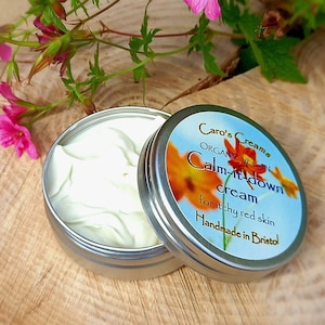 May include: A silver tin of Caro's Creams Calm-it-down cream for itchy red skin. The tin is open and the cream is visible. The tin is handmade in Bristol.