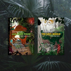 May include: Two postcard packs featuring artwork from Michael Crichton's novels. The left pack shows orange dinosaurs with the text Greetings From Jurassic Park Postcard Pack. The right pack shows green dinosaurs with The Lost World Postcard Pack.