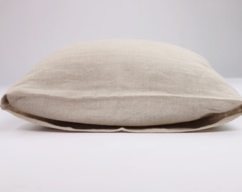 May include: A beige linen pillow with a simple, folded design. The pillow is made of natural fabric and has a soft, textured surface.