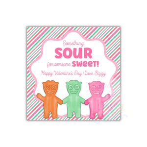 May include: A Valentine's Day card featuring three colorful candy characters in orange, green, and pink, holding hands. The card has a pink and white striped background and text that reads "Something SOUR for someone SWEET!"