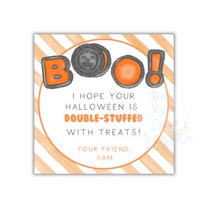 May include: A square Halloween-themed card with orange and white diagonal stripes. The word "BOO!" is written in orange and gray letters. The text "I hope your Halloween is double-stuffed with treats!" is also included.