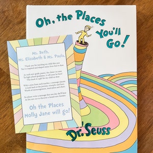 May include: A colorful book titled "Oh, the Places You'll Go!" by Dr. Seuss. A smaller card with a message thanking teachers for their work and a personalized message for a student named Molly Jane is placed on top of the book.