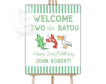 May include: Welcome to da Bayou sign with green and white stripes. The sign features a cartoon alligator, crawfish, and pelican. The text reads "Welcome to da Bayou, Happy 2nd Birthday, John Robert!"