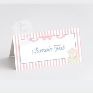 May include: Pink and white striped place card with a blue border. The card has a pink bow and a small illustration of a carousel. The text "Sample Text" is printed in blue on the card.